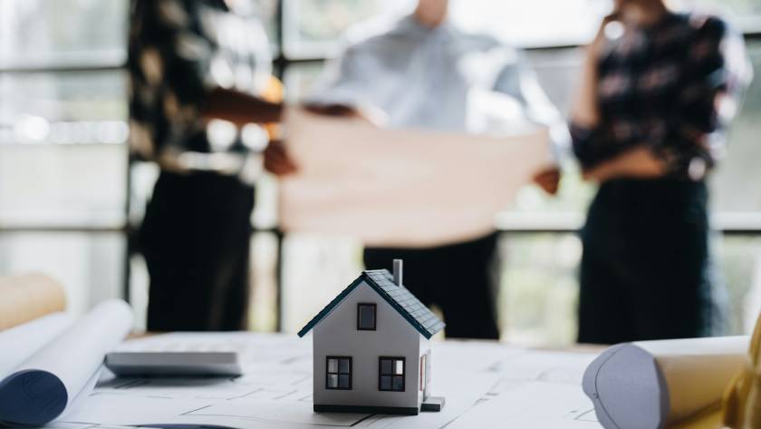 business engineering teamwork discussing a new building project with home model to successful busine