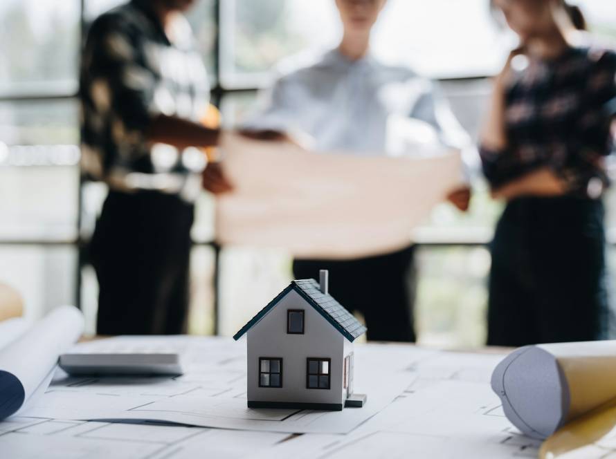 business engineering teamwork discussing a new building project with home model to successful busine