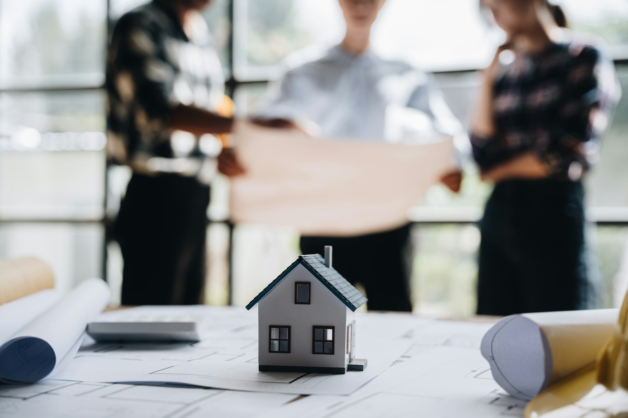 business engineering teamwork discussing a new building project with home model to successful busine